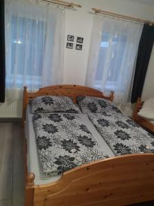 沙羅什保陶克的住宿－Oázis Apartman，一间卧室配有一张带黑白床单的木床。