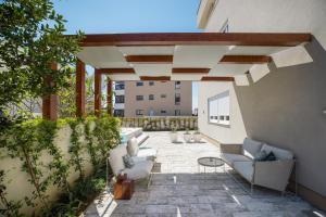 un patio con sofás y sillas en un edificio en Ika Boutique Luxury Apartments, en Zadar