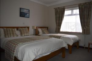 a hotel room with two beds and a window at Cois Farraige in Lahinch