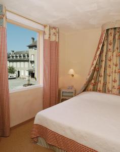 a bedroom with a bed and a large window at Hotel Le Viscos - Teritoria in Saint-Savin