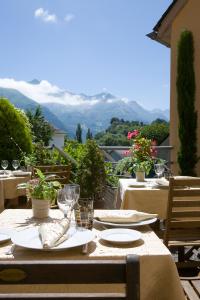 a table with plates and glasses and a view of mountains at Hotel Le Viscos - Teritoria in Saint-Savin