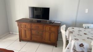 a television on a wooden dresser in a room at Apto lateral mar in Porto Belo