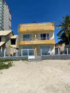 a building on the beach next to the sand at Apto lateral mar in Porto Belo