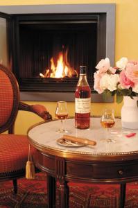 una bottiglia di vino e due bicchieri su un tavolo con camino di Hotel Le Viscos - Teritoria a Saint-Savin