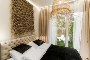 1 dormitorio con 1 cama grande con almohadas blancas y negras en Apartament Black, en Mielno
