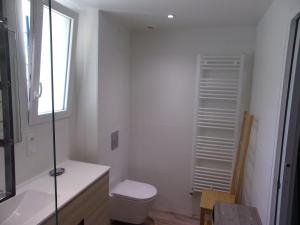 biała łazienka z toaletą i oknem w obiekcie agapanthe w mieście Crozon