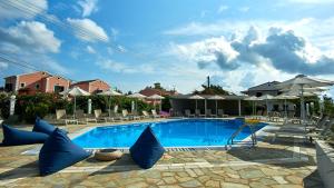 a swimming pool with blue pillows on the ground at Seaside Suites in Kavos
