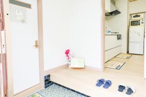 un paio di sandali seduti sul pavimento di una cucina di HAT Kujo, near from Kintetsu Kujo station 近鉄九条駅前の民泊 a Kōriyama