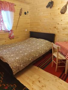 a bedroom with a bed and a table and a window at Etno domacinstvo Uvacki konaci in Nova Varoš