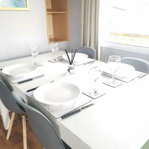 uma mesa de jantar com pratos brancos e copos de vinho em No99 Static Caravan Widemouth Fields 3 mins from beach em Poundstock