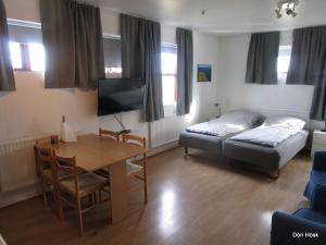 a bedroom with a bed and a table and a bed and a desk at Sunna's Guesthouse in Drangsnes