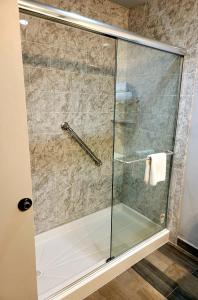 y baño con ducha y puerta de cristal. en Blue Bay Inn and Suites en South Padre Island