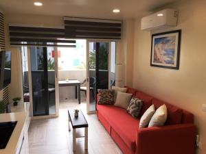 een woonkamer met een rode bank en een tafel bij Atlantic Coast Apartment - Playa Del Inglés in Playa del Inglés