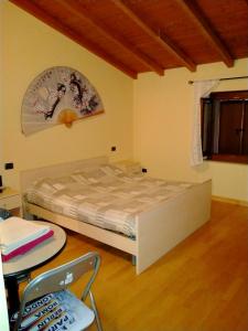 1 dormitorio con 1 cama, 1 mesa y 1 silla en B&B Aurora, en Cavaion Veronese