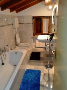 La salle de bains est pourvue d'une baignoire, d'un lavabo et de 2 toilettes. dans l'établissement B&B Aurora, à Cavaion Veronese