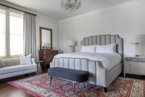 a bedroom with a bed and a chair and a couch at La Colombe d'Or Hotel in Houston