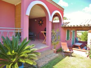 uma casa cor-de-rosa com um alpendre e um pátio em SoleeSale Appartamenti e Camere Per Vacanza em Pula