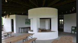 a room with benches and tables in a building at Aranyló Vendégház in Alsótelekes