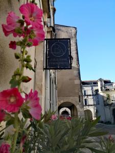 una señal en el lateral de un edificio con flores rosas en La Belle Amarre-Bed and Breakfast-Maison d'Hôtes en La Rochelle