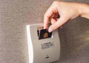 a hand is pushing a button on a lightswitch at APA Hotel Namba Shinsaibashi Nishi in Osaka