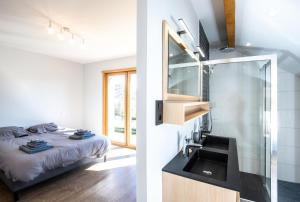 uma casa de banho com um lavatório e uma cama num quarto em Moho Mountain Home em Gérardmer