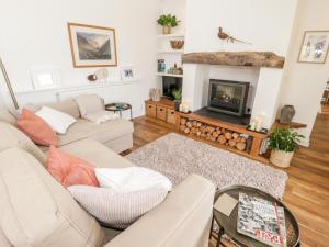 a living room with a couch and a fireplace at Beudy Hywel in Caernarfon