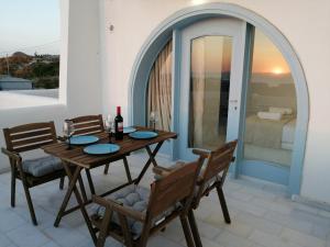 a wooden table and chairs on a patio at Plaka's house seaside view in Plaka