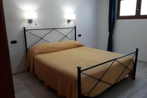 Una cama en una habitación con dos luces encima. en Incantos Charme B&B & Apartment en Tortolì