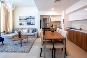a kitchen and living room with a table and a couch at A Luxury Aprt 2 bedrooms Balcony with wonderful view Mall access hi speed WIFI Beach access & much more for Family Only in Rayyā