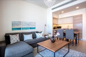 a living room with a couch and a table at A Luxury Aprt 2 bedrooms Balcony with wonderful view Mall access hi speed WIFI Beach access & much more for Family Only in Rayyā