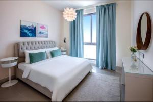 a bedroom with a large white bed and a window at A Luxury Aprt 2 bedrooms Balcony with wonderful view Mall access hi speed WIFI Beach access & much more for Family Only in Rayyā