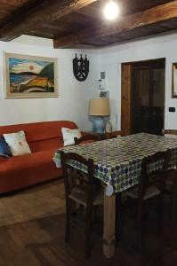 a living room with a table and a red couch at ViviMontagna Mathilda in Perosa Argentina