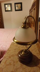 a lamp sitting on a table next to a bed at ViviMontagna Mathilda in Perosa Argentina