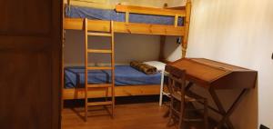 a room with two bunk beds and a desk at ViviMontagna Mathilda in Perosa Argentina