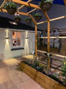 a patio with potted plants and a wooden pergola at Domo Boutique Hotel in Oldbury