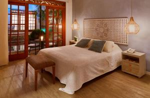 um quarto com uma cama, uma cadeira e uma mesa em Lombok Hotel & SPA antes Hotel Casablanca em Guaduas