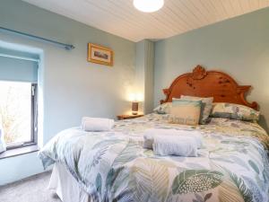 a bedroom with a large bed with towels on it at Barn Court Cottage in Narberth