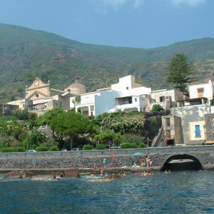 un grupo de personas nadando en el agua cerca de un puente en La Casa di Via Lungomare, en Santa Marina Salina