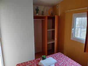 Habitación pequeña con cama y ventana en Chalet-home familiar "CAL ÍNDIA" "Pet friendly", en Sant Carles de la Ràpita
