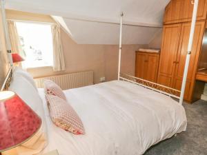 a bedroom with a white canopy bed with a window at Aber Clwyd Manor in Corwen