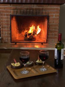 a tray with two glasses of wine and a fireplace at Chácara Cantinho que Deus me Deu in Sao Paulo