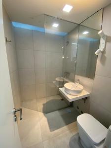 une salle de bain avec un lavabo, des toilettes et un miroir dans l'établissement Arvore Beach House, à Porto 16 autres photos