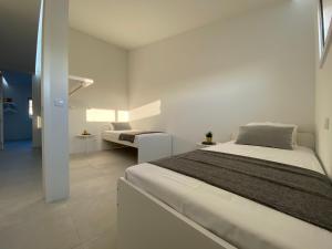 - une chambre blanche avec un lit et un canapé dans l'établissement Arvore Beach House, à Porto