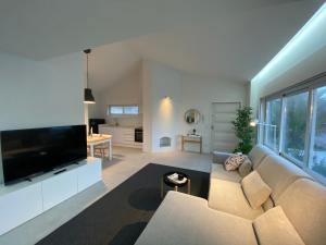 - un salon avec un canapé et une grande télévision dans l'établissement Arvore Beach House, à Porto