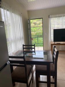 uma mesa de jantar com 2 cadeiras e uma televisão em Aparthotel Sabalito em Sabalito