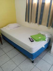 a small bed with a green bag on it at HOSTAL CASA PILAR in Masaya