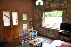 a living room with two chairs and a window at Cabañas La Pampilla in San Javier