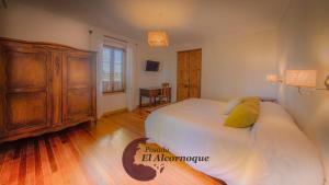 um quarto com uma cama grande e uma cómoda em madeira em Posada El Alcornoque em São Rafael