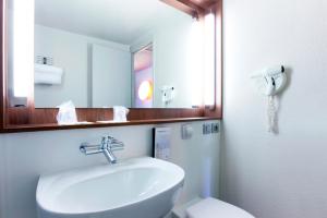 エキュリにあるカンパニール リヨン ノール エキュリのバスルーム(洗面台、鏡、トイレ付)
