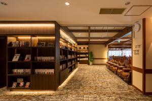 a library with chairs and bookshelves at Hotel Grand Vert Kyu Karuizawa in Karuizawa